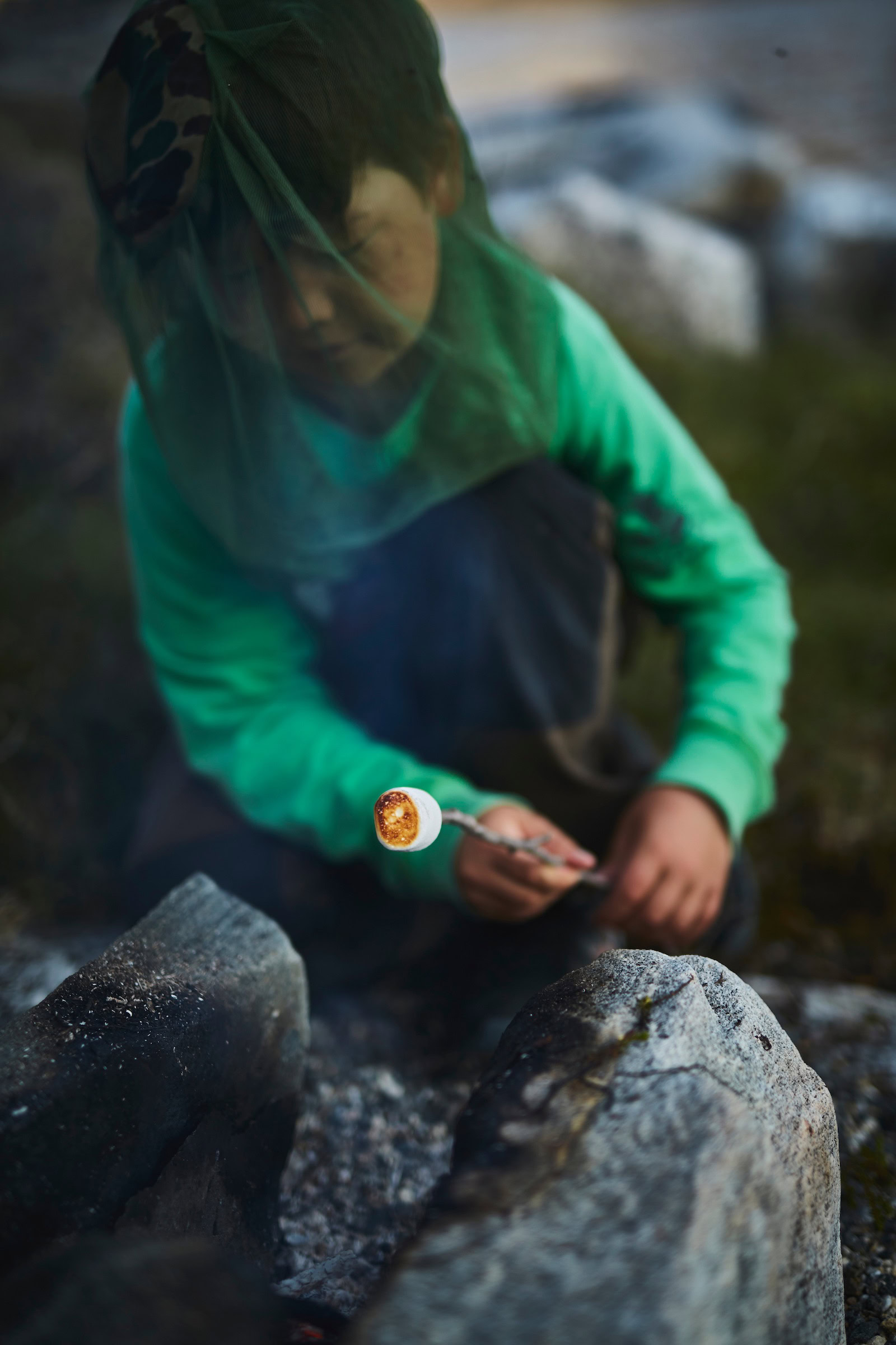 A boy roasting a marshmallow over a bonfire in Nuuk