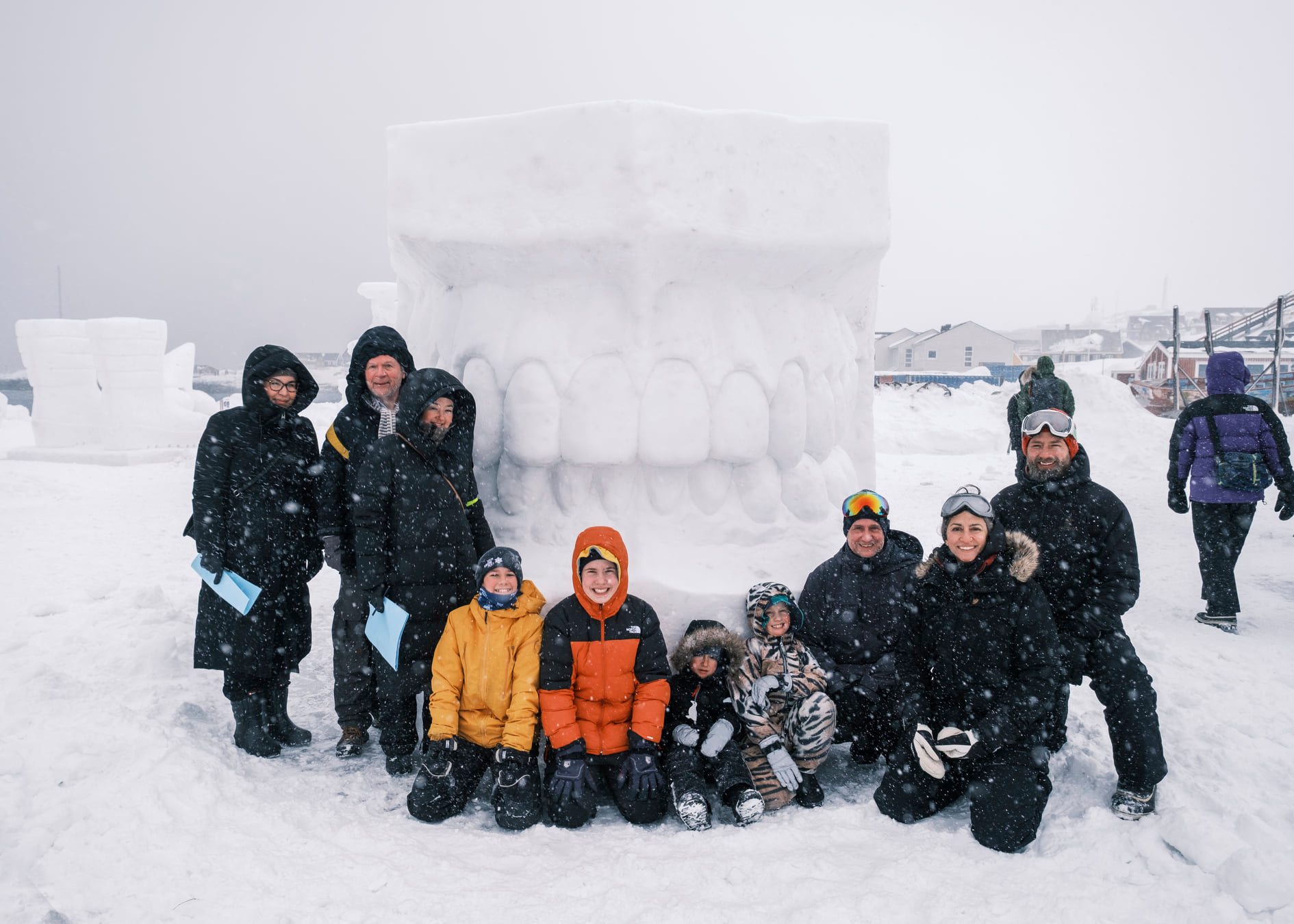 Adults_and_kids_in_front_of_snow_sculpture_made_of_teeth_in_snowy_weather_photo_cebastian_rosing_2022